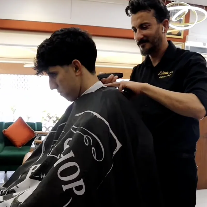 Coiffeur et client au fauteuil dans le salon
