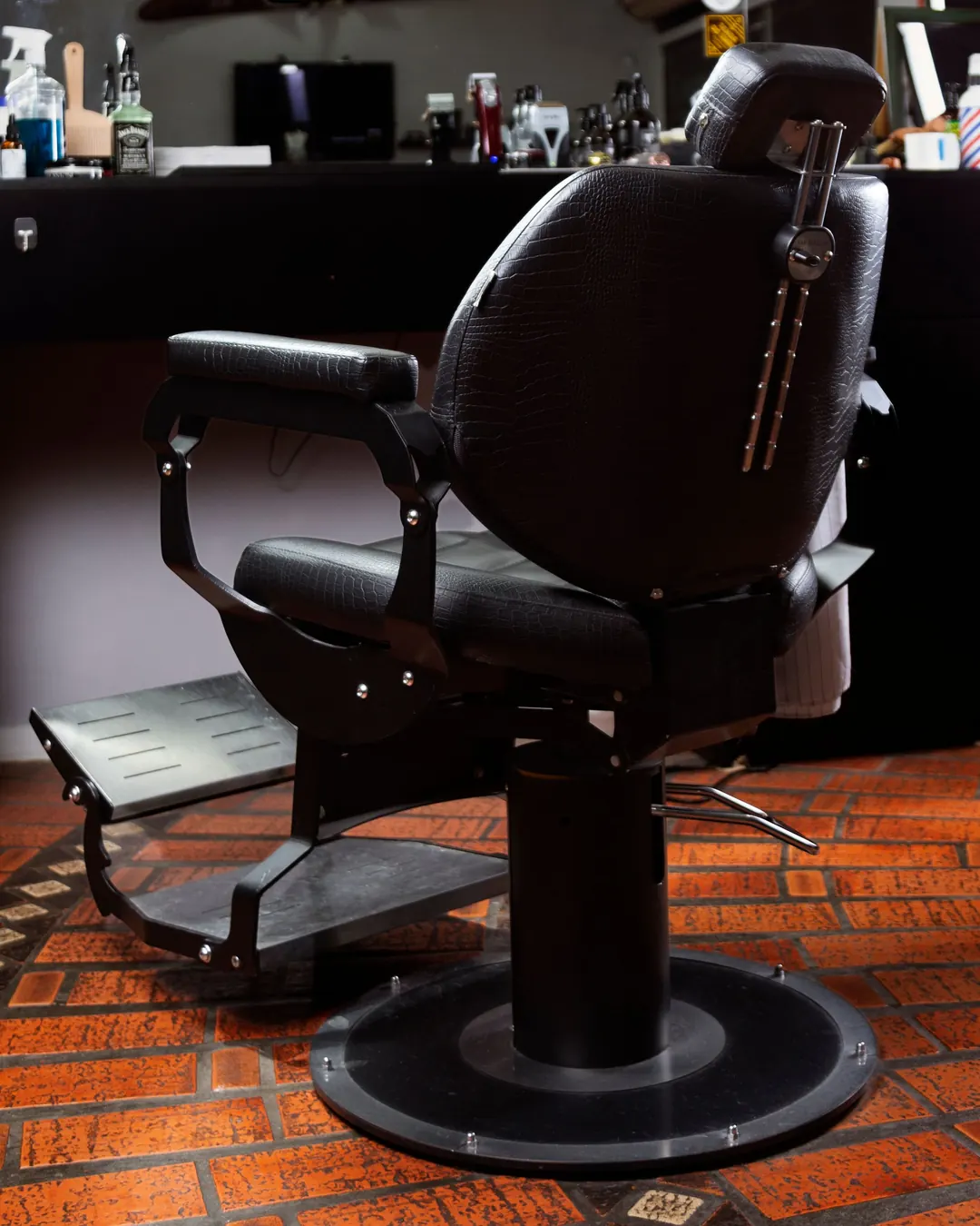 Fauteuil de barbier noir sur un sol en briques