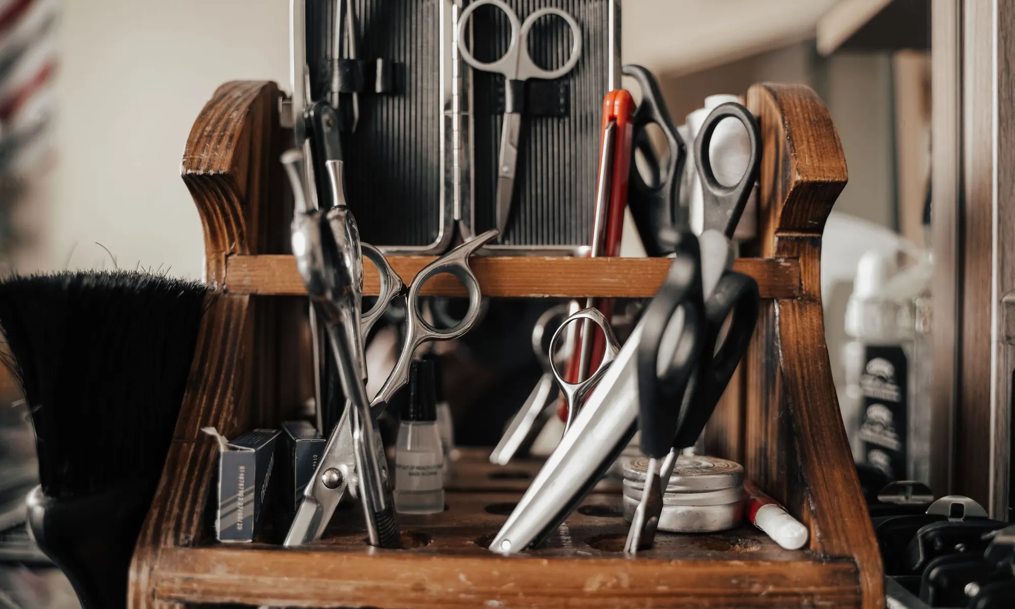 Ciseaux et outils de barbier rangés dans un présentoir en bois